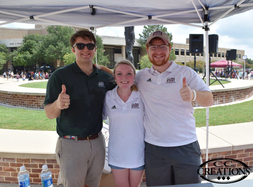 Big Event at Texas A&M wearing custom embroidered polos with their logo in maroon while giving a thumbs up (gig 'em)